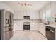 Bright kitchen with white cabinets, stainless steel appliances, and stylish backsplash at 3073 Hopeland Dr, Powder Springs, GA 30127