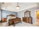 The main bedroom has an ornate bed with a chandelier hanging from the tray ceiling at 3073 Hopeland Dr, Powder Springs, GA 30127