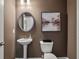 Elegant powder room featuring a pedestal sink, decorative mirror, and stylish wall art at 323 Silver Leaf Trce, Douglasville, GA 30134