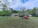 Well-maintained home with a green lawn and a small out-building surrounded by trees and flowering shrubs at 4445 Moon Station Nw Ln, Acworth, GA 30101