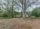 Home with a sprawling front yard, mature trees, and a glimpse of a charming porch and out-building at 4445 Moon Station Nw Ln, Acworth, GA 30101