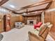 Living room with wood walls and beams with fireplace and large ceiling fan at 4445 Moon Station Nw Ln, Acworth, GA 30101