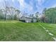 The house has a simple design with gray walls, a green yard and many trees at 4445 Moon Station Nw Ln, Acworth, GA 30101