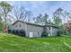 The house has a simple design with gray walls, a green yard and many trees at 4445 Moon Station Nw Ln, Acworth, GA 30101