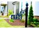 Close up on a black address sign with gold numbers on a green lawn at 4734 Dewitt Dr, Duluth, GA 30097