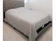 Cozy carpeted bedroom with a tufted headboard, light gray bedding, and neutral decor at 4734 Dewitt Dr, Duluth, GA 30097
