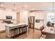 Well-lit kitchen features island seating, stainless steel appliances and white cabinetry at 4734 Dewitt Dr, Duluth, GA 30097