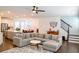 Bright, open-concept living space with a gray sectional, seamlessly connecting kitchen and dining at 4734 Dewitt Dr, Duluth, GA 30097