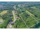 Aerial view highlights the property lines of a lush, wooded lot amidst a neighborhood setting with mature trees at 558 Auburn Rd, Auburn, GA 30011