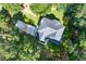 Aerial view of a house featuring a well-maintained roof, driveway, and a green lawn with mature trees at 558 Auburn Rd, Auburn, GA 30011