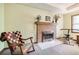 Cozy bedroom area showcases a brick fireplace, comfortable rocking chair, and bright natural light at 558 Auburn Rd, Auburn, GA 30011