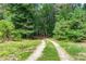 A rustic gravel driveway leads through a lush green landscape providing a secluded entrance at 558 Auburn Rd, Auburn, GA 30011