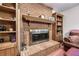 Close-up of a brick fireplace with a wood mantel and built-in bookshelves in the living room at 558 Auburn Rd, Auburn, GA 30011