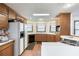 Traditional kitchen with wood cabinets, white countertops, and a bay window overlooking the backyard at 558 Auburn Rd, Auburn, GA 30011