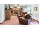 Cozy living room with a brick fireplace, built-in bookshelves, ceiling fan and leather furniture at 558 Auburn Rd, Auburn, GA 30011