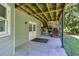 View of a covered patio underneath a wooden deck, perfect for outdoor entertaining at 558 Auburn Rd, Auburn, GA 30011