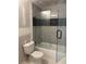 Modern bathroom featuring updated shower and bath with glass doors and tile surround with dark accent row at 2256 Mack Rd, Douglasville, GA 30135