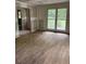 View of a living room with attached restroom, showcasing new floors and drywall at 2256 Mack Rd, Douglasville, GA 30135