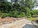 Stone patio with landscaping and retaining wall makes an inviting outdoor space at 2308 Littlebrooke Dr, Dunwoody, GA 30338