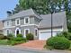 Charming gray home with a brick driveway, manicured lawn, and mature trees at 2308 Littlebrooke Dr, Dunwoody, GA 30338