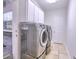 Modern laundry room with stainless steel washer and dryer, and tiled floors at 2308 Littlebrooke Dr, Dunwoody, GA 30338