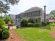 Expansive rear exterior featuring a stone patio, well-manicured lawn, and mature landscaping at 2308 Littlebrooke Dr, Dunwoody, GA 30338