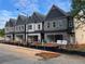 New townhomes featuring mixed brick and siding exterior, garages, and classic architectural details under a partly cloudy blue sky at 3104 Marbella Cir # 2, Kennesaw, GA 30152