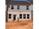 Back exterior of townhome featuring gray siding and brick details, several windows, and a back door at 3104 Marbella Cir # 2, Kennesaw, GA 30152
