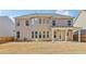 Expansive backyard featuring a covered patio, large windows, and a well-manicured lawn at 1147 Trident Maple Chase, Lawrenceville, GA 30045