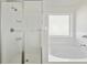 Modern bathroom featuring walk in shower with glass enclosure and soaking tub at 1147 Trident Maple Chase, Lawrenceville, GA 30045
