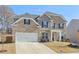 Inviting two-story brick home featuring a spacious driveway and attractive landscaping at 1147 Trident Maple Chase, Lawrenceville, GA 30045