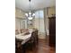 Formal dining room featuring hardwood floors, large window, elegant chandelier and table setting at 133 Titan Rd, Stockbridge, GA 30281