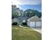 Charming single-story home with a two-car garage, stone accents, and manicured lawn at 133 Titan Rd, Stockbridge, GA 30281