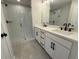 Modern bathroom featuring a glass enclosed shower, double vanity, and sleek gray tile flooring at 1923 Cassia Aly, Kennesaw, GA 30144