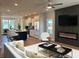 Open living room with modern fireplace, ceiling fan, hardwood floors and kitchen in the background at 1923 Cassia Aly, Kennesaw, GA 30144
