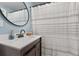 Modern bathroom featuring a wood vanity with marble countertop and a striped shower curtain at 405 Miller Rd, Covington, GA 30014