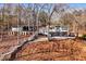 Lake house with wooden staircase leading to the gray, two-story home and covered parking area at 405 Miller Rd, Covington, GA 30014