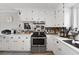 Kitchen featuring white cabinetry, stainless steel appliances, and marble countertops at 405 Miller Rd, Covington, GA 30014