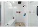 Close-up of a white tiled shower with glass doors and a tiled shower bench at 405 Miller Rd, Covington, GA 30014