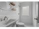 Bright bathroom featuring subway tile, shower-tub combo, white fixtures, and shelves for storage at 960 Byron Sw Dr, Atlanta, GA 30310