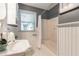 Cozy bathroom featuring a shower-tub combo, beadboard paneling, and a stylish pedestal sink at 1145 Arbordale Dr, Decatur, GA 30033