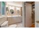 Bright bathroom with double sink vanity, oval mirrors, and tile flooring next to the walk-in closet at 1145 Arbordale Dr, Decatur, GA 30033