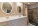 Bathroom featuring double sink vanity, oval mirrors, and tiled shower with shower curtain at 1145 Arbordale Dr, Decatur, GA 30033