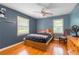 Bedroom with hardwood floors, two windows, ceiling fan and a small wooden chair at 1145 Arbordale Dr, Decatur, GA 30033