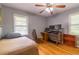 Bedroom with hardwood floors, two windows, a ceiling fan, and a desk and bookshelf at 1145 Arbordale Dr, Decatur, GA 30033