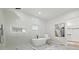 Modern bathroom featuring a soaking tub, a glass-enclosed shower, and elegant marble-like tile at 223 Altoona Sw Pl, Atlanta, GA 30314