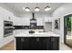 Modern kitchen with white cabinets, a black island with marble countertop, and stainless steel appliances at 223 Altoona Sw Pl, Atlanta, GA 30314