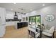 Open-concept kitchen with island, stainless appliances, black backsplash, and an adjacent dining area at 223 Altoona Sw Pl, Atlanta, GA 30314