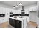 Modern kitchen with white cabinets, black island with marble countertop, and stainless steel appliances at 223 Altoona Sw Pl, Atlanta, GA 30314