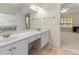 Bright bathroom featuring double sinks, white cabinets, a large mirror and tile flooring at 240 Huiet Dr, Mcdonough, GA 30252